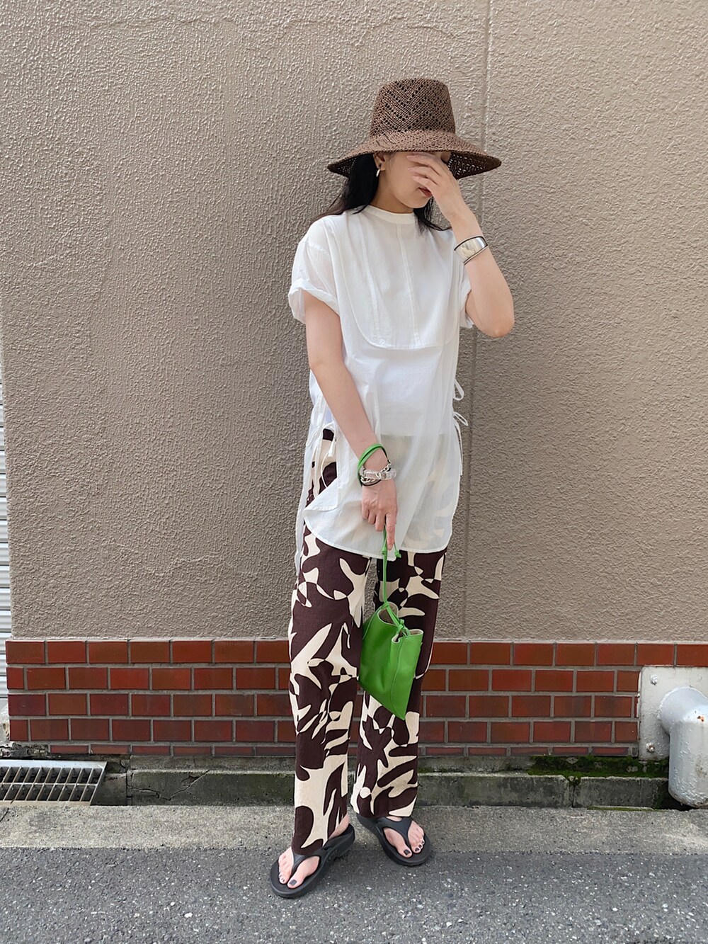 ホワイト系のシャツ/ブラウス、グリーン系のハンドバッグ、ブラック系のサンダルを着用したレディースの春コーディネートの2枚目の写真