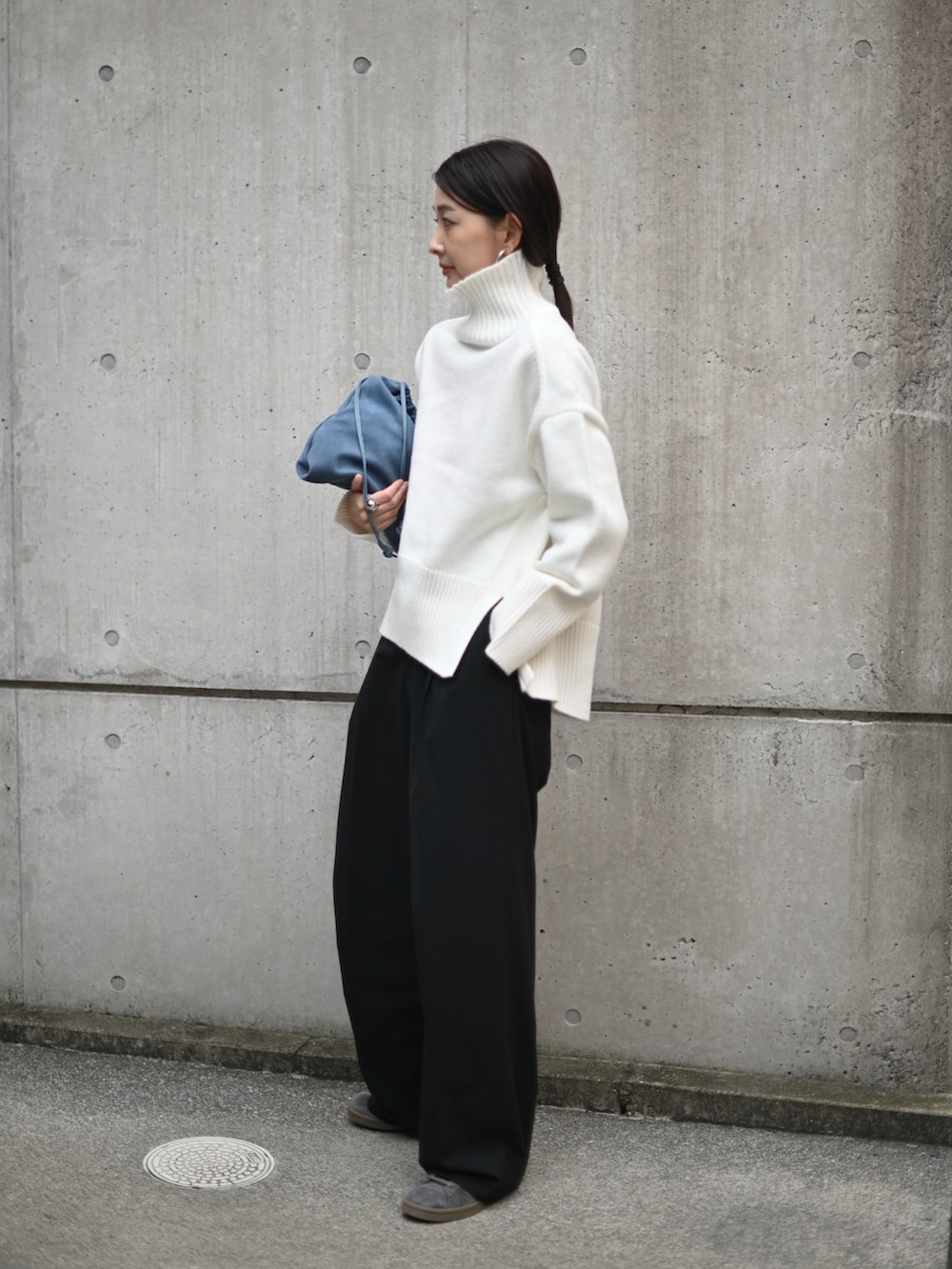 ホワイト系のニット/セーター、ブラック系のスニーカー、ブラック系のその他アウターを着用したレディースの冬コーディネートの2枚目の写真