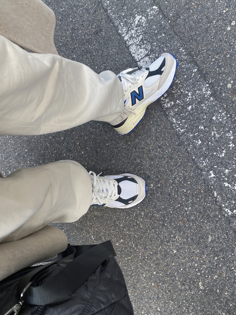 ホワイト系のスニーカー、ホワイト系のスウェットパンツ、ブラック系のトートバッグを着用したレディースの冬コーディネートの4枚目の写真