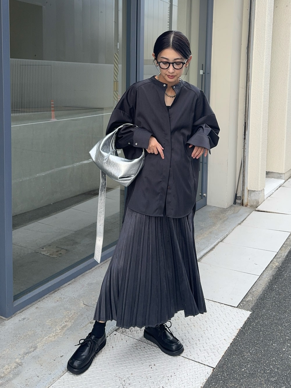 グレー系のスカート、グレー系のシャツ/ブラウス、シルバー系のショルダーバッグを着用したレディースの秋コーディネートの3枚目の写真