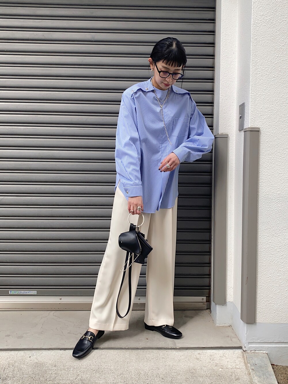 ブルー系のシャツ/ブラウス、ブラック系のショルダーバッグ、ブラック系のローファーを着用したレディースの春コーディネートの4枚目の写真