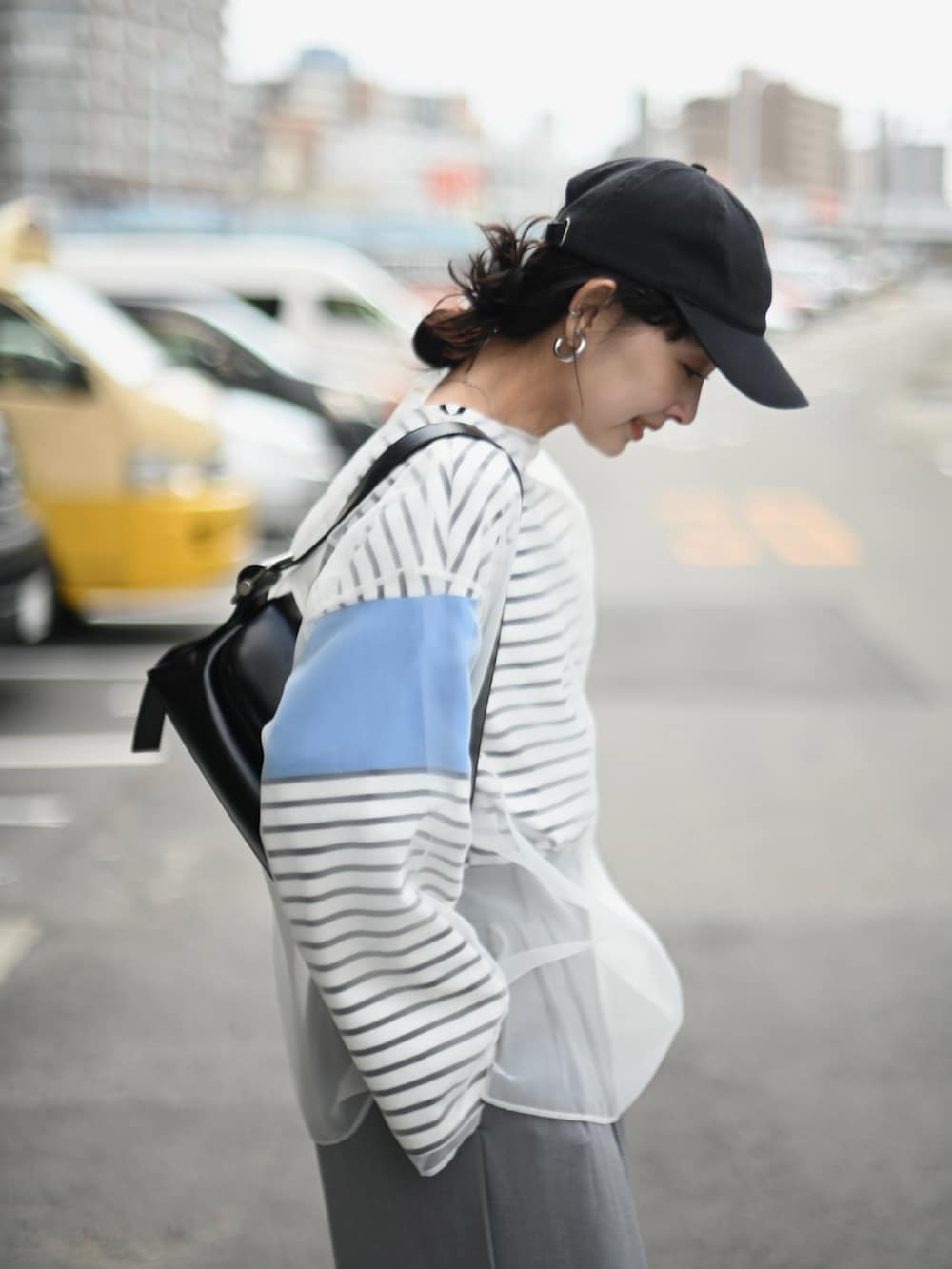 ホワイト系のシャツ/ブラウス、ブルー系のTシャツ/カットソー、ブラック系のショルダーバッグを着用したレディースの春コーディネートの4枚目の写真