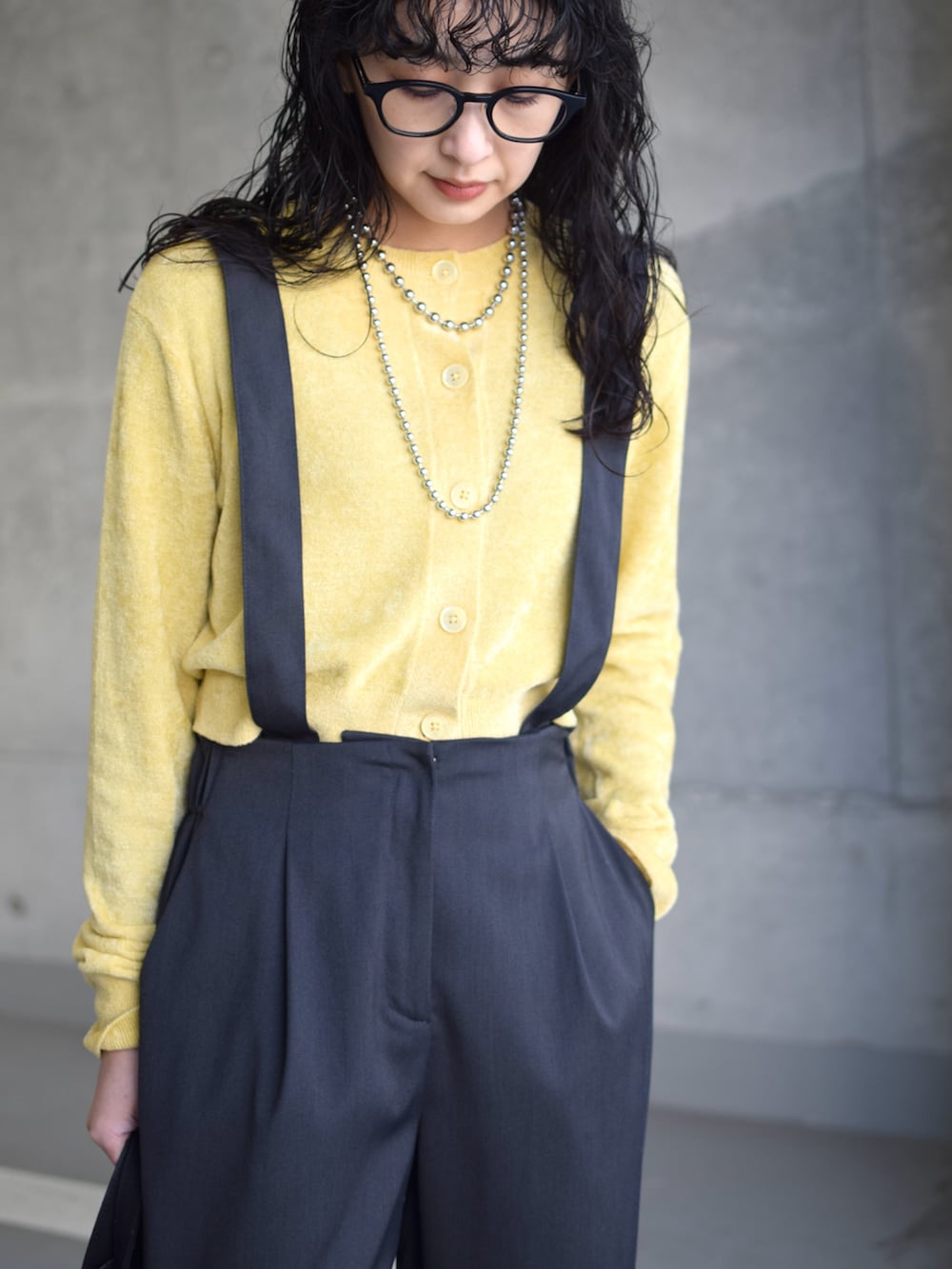 グレー系のブルゾン、イエロー系のカーディガン/ボレロ、グレー系のスラックスを着用したレディースの冬コーディネートの2枚目の写真