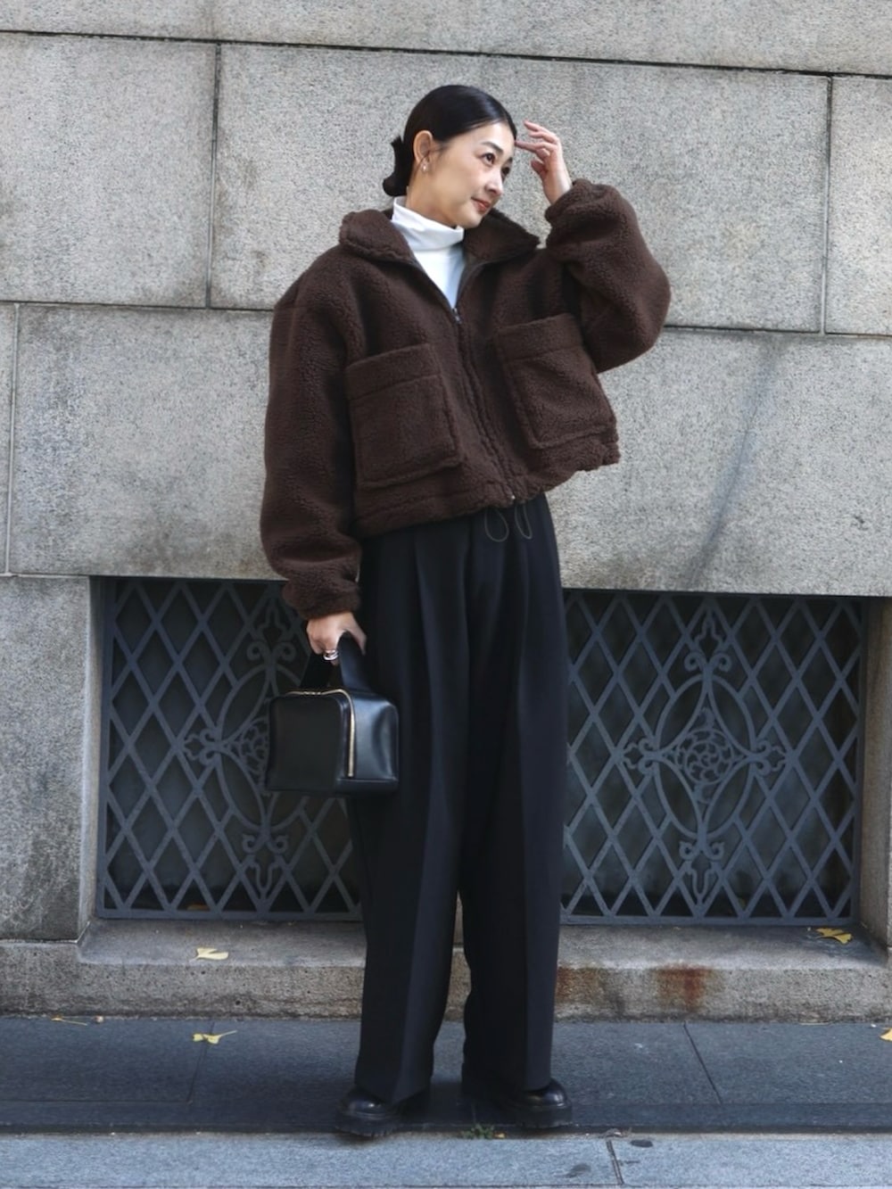 ブラウン系のその他アウター、ブラック系のスラックス、ブラック系のブーツを着用したレディースの冬コーディネートの5枚目の写真