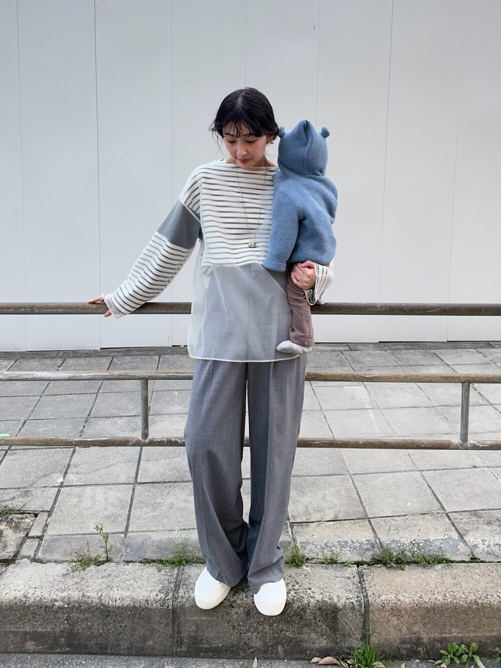 ホワイト系のシャツ/ブラウス、ブラック系のTシャツ/カットソー、グレー系のスラックスを着用したレディースの春コーディネートの2枚目の写真