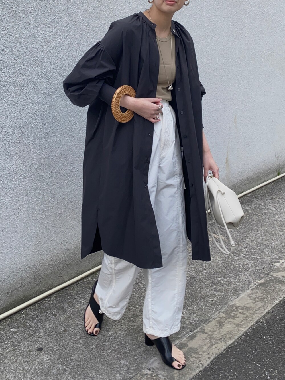 ブラック系のシャツワンピース、ホワイト系のその他パンツ、シルバー系のネックレスを着用したレディースの春コーディネートの2枚目の写真