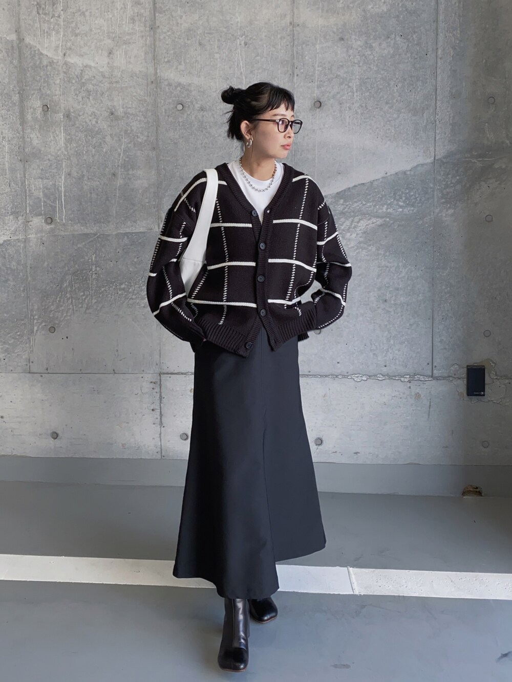 ブラック系のカーディガン/ボレロ、ブラック系のスカート、ホワイト系のトートバッグを着用したレディースの冬コーディネートの5枚目の写真