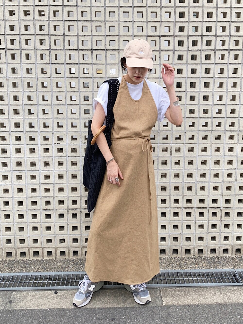 ベージュ系のワンピース、ブラック系のトートバッグ、グレー系のスニーカーを着用したレディースの秋コーディネートの2枚目の写真