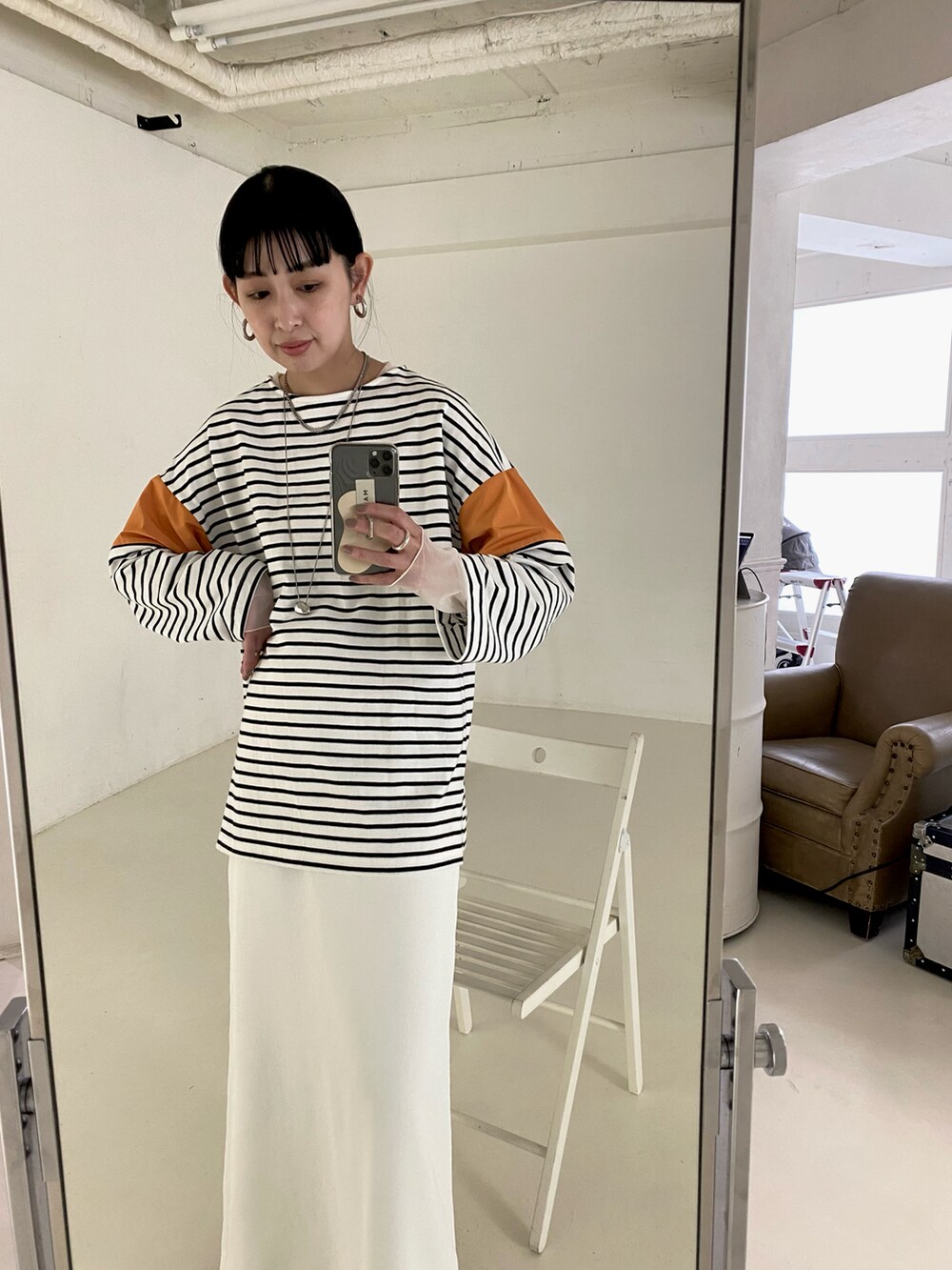 オレンジ系のTシャツ/カットソー、ホワイト系のキャミソール、シルバー系のネックレスを着用したレディースの春コーディネートの3枚目の写真