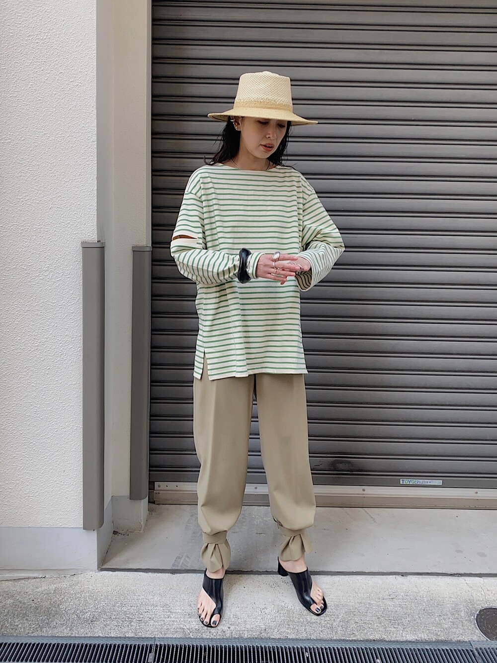 グリーン系のTシャツ/カットソー、ベージュ系のその他パンツ、ブラック系のブレスレットを着用したレディースの春コーディネートの2枚目の写真