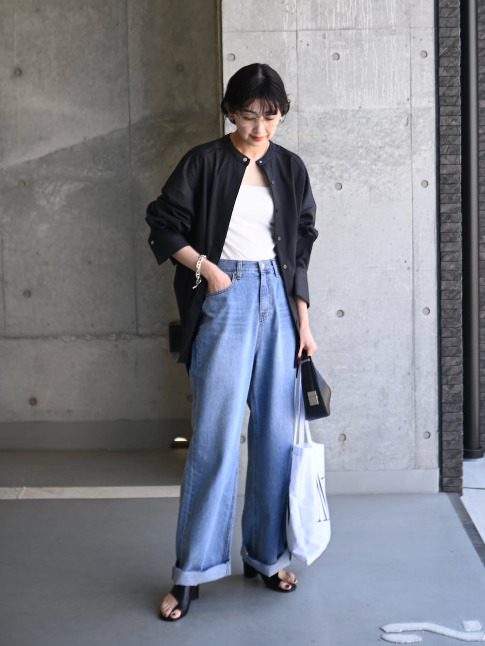 グレー系のシャツ/ブラウス、ホワイト系のトートバッグ、ブラック系のハンドバッグを着用したレディースの春コーディネートの2枚目の写真