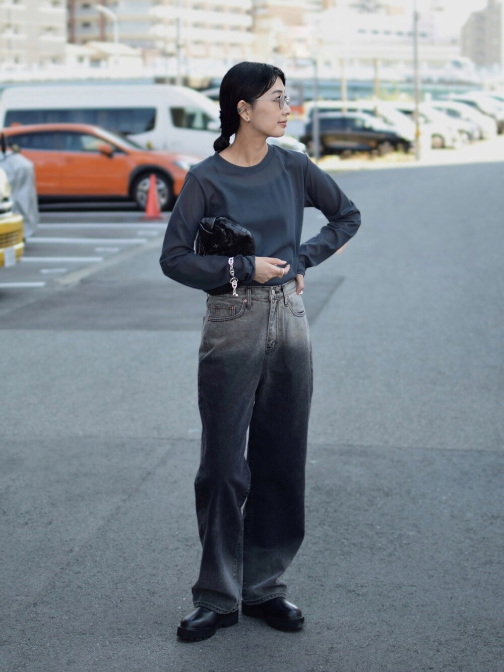 グレー系のTシャツ/カットソー、ブラック系のブーツ、ブラック系のデニムパンツを着用したレディースの秋コーディネートの2枚目の写真