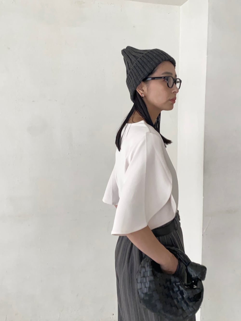 ホワイト系のTシャツ/カットソー、ブラック系のハンドバッグ、ブラック系のブーツを着用したレディースの秋コーディネートの3枚目の写真