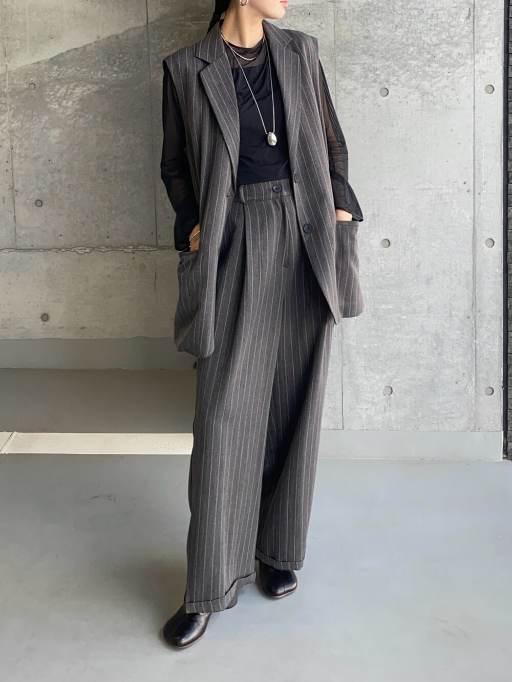 グレー系のその他アウター、グレー系のスラックス、ブラック系のブーツを着用したレディースの秋コーディネートの2枚目の写真