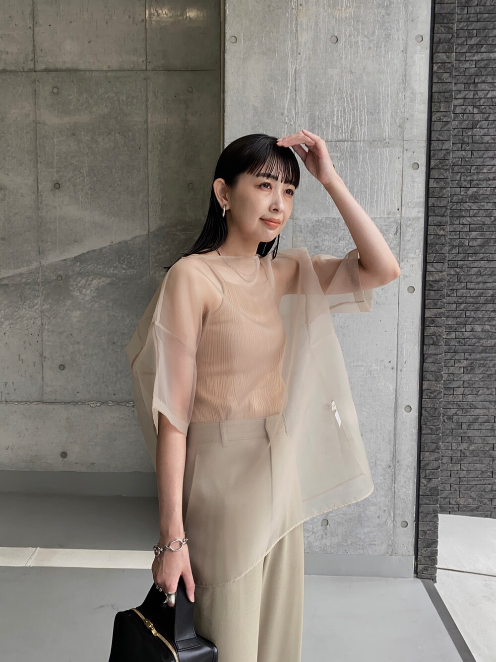 ベージュ系のシャツ/ブラウス、ブラック系のバレエシューズ、ブラック系のハンドバッグを着用したレディースの秋コーディネートの2枚目の写真