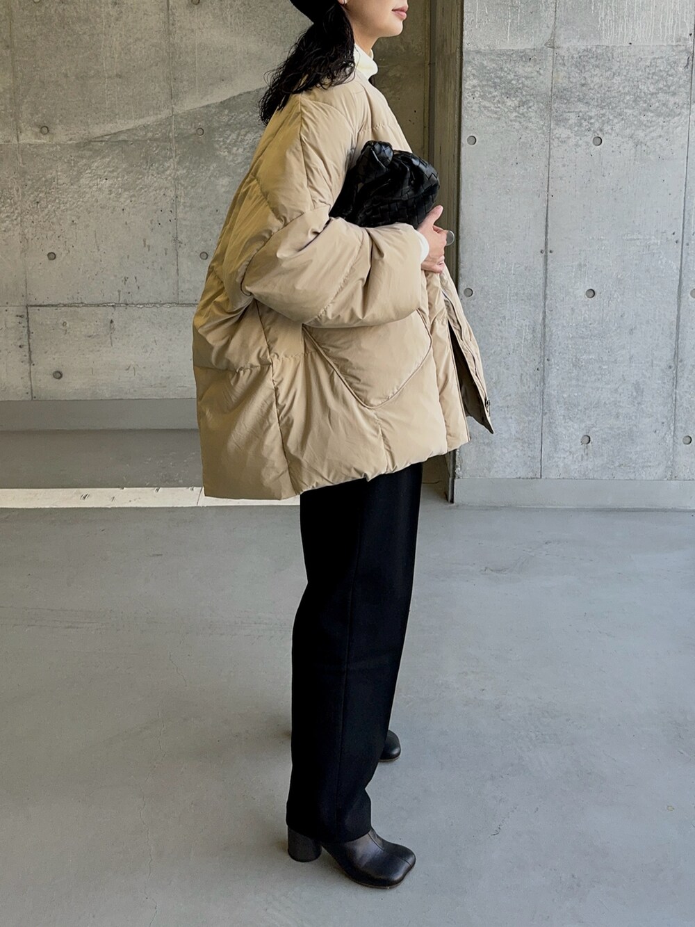 ベージュ系のダウンジャケット/コート、ブラック系のブーツ、ブラック系のハットを着用したレディースの冬コーディネートの3枚目の写真