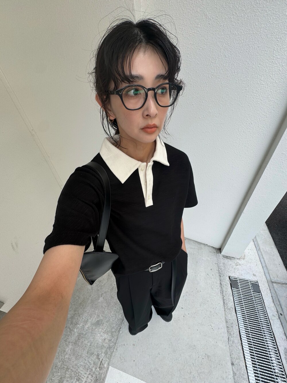 ブラック系のTシャツ/カットソー、ブラック系のスラックス、ブラック系のショルダーバッグを着用したレディースの夏コーディネートの4枚目の写真