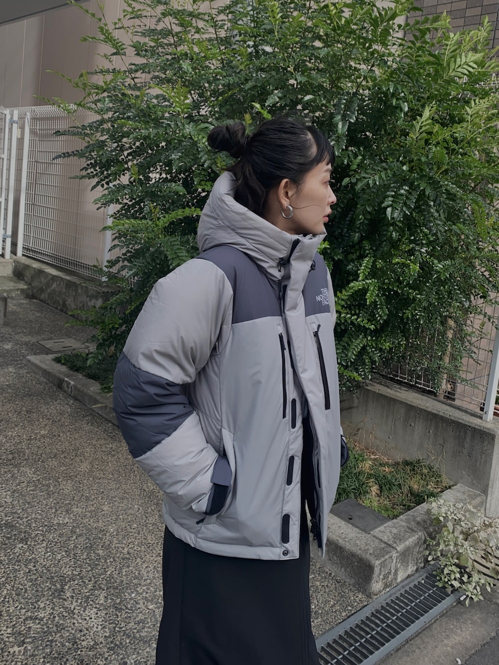 グレー系のその他アウター、ブラック系のスカート、ブラック系のスニーカーを着用したレディースの冬コーディネートの2枚目の写真