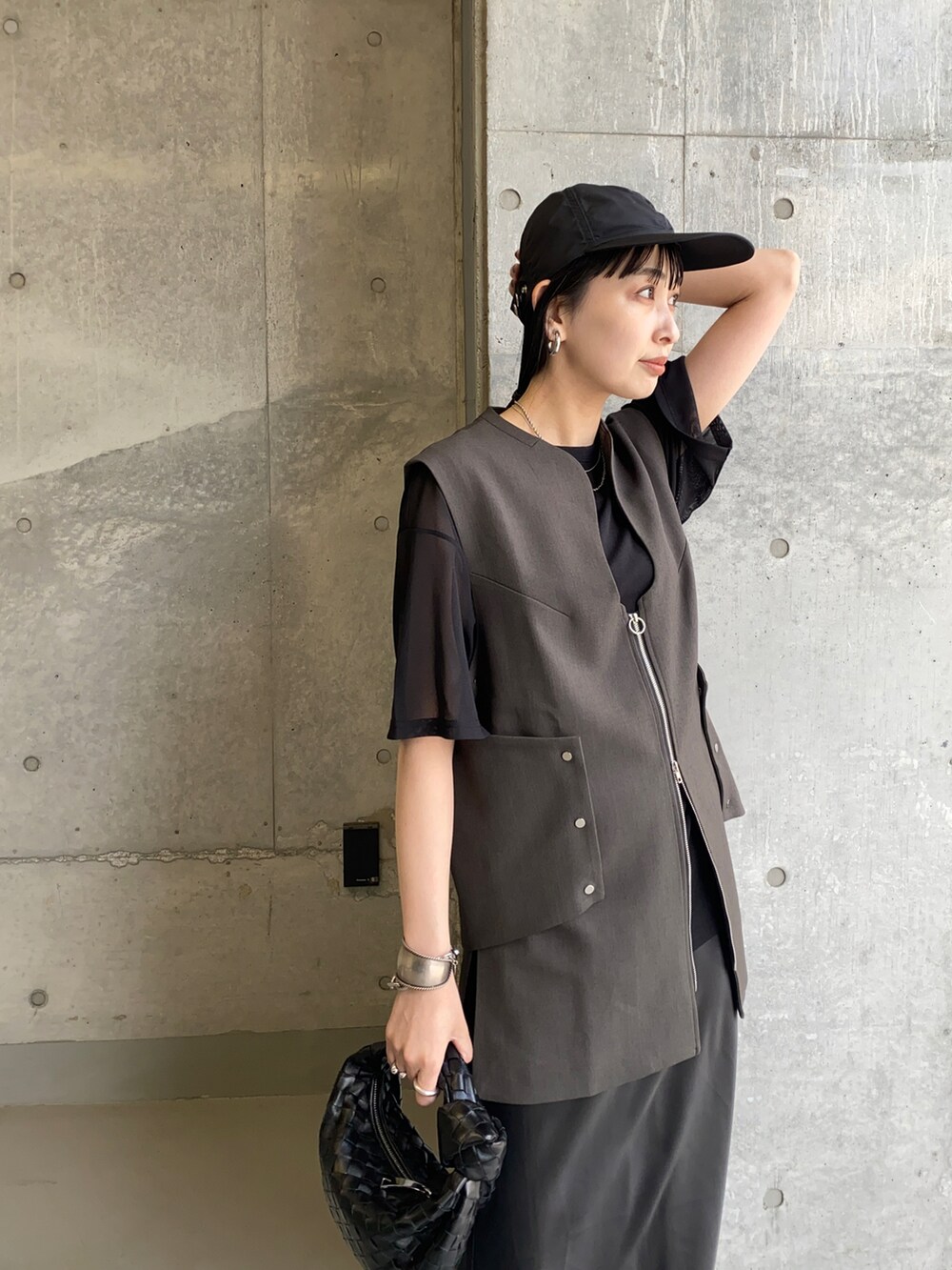 ブラック系のTシャツ/カットソー、グレー系のベスト、ブラック系のサンダルを着用したレディースの夏コーディネートの2枚目の写真