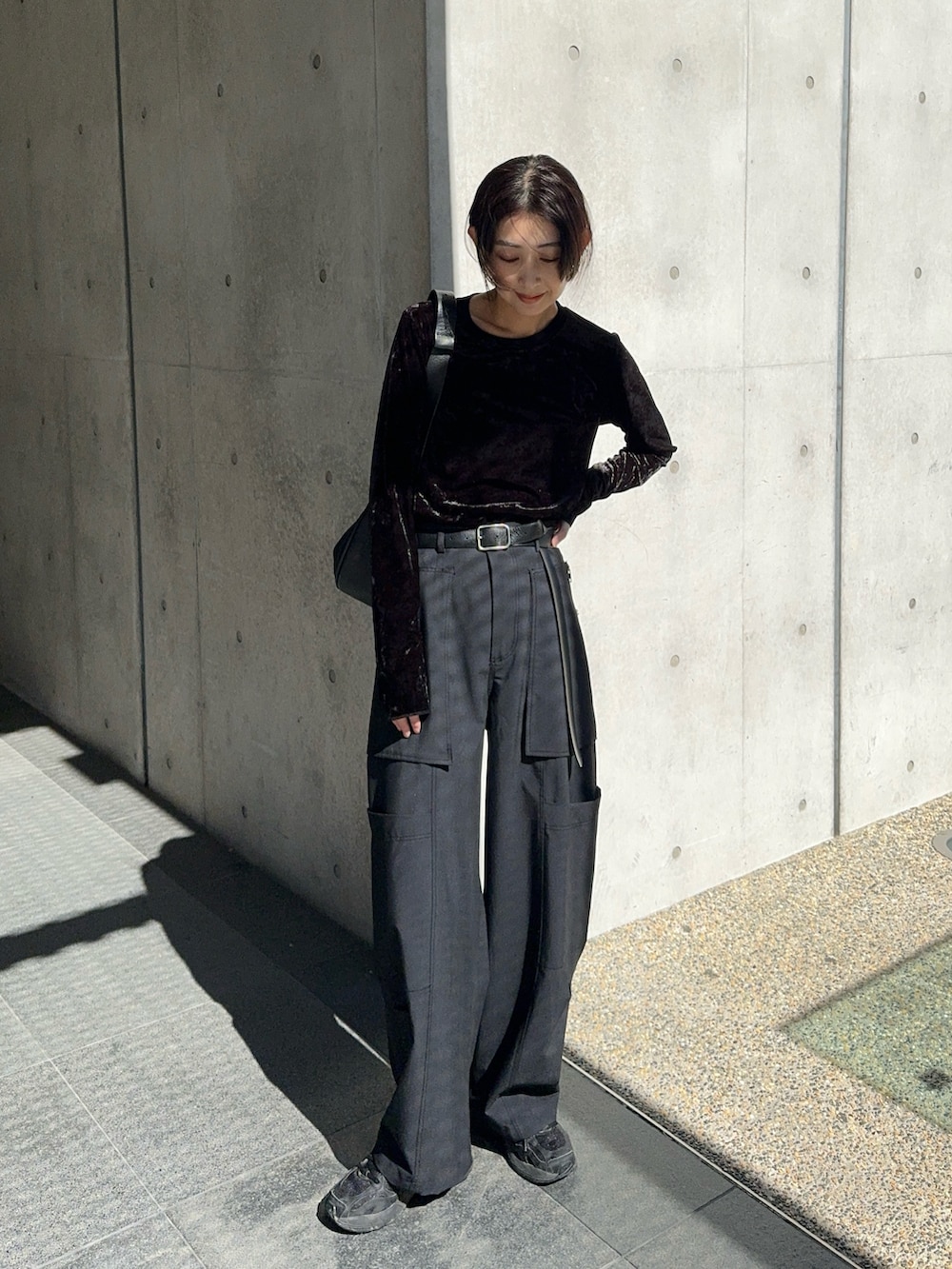 ブラック系のTシャツ/カットソー、ブラック系のショルダーバッグ、ブラック系のスニーカーを着用したレディースの秋コーディネートの4枚目の写真