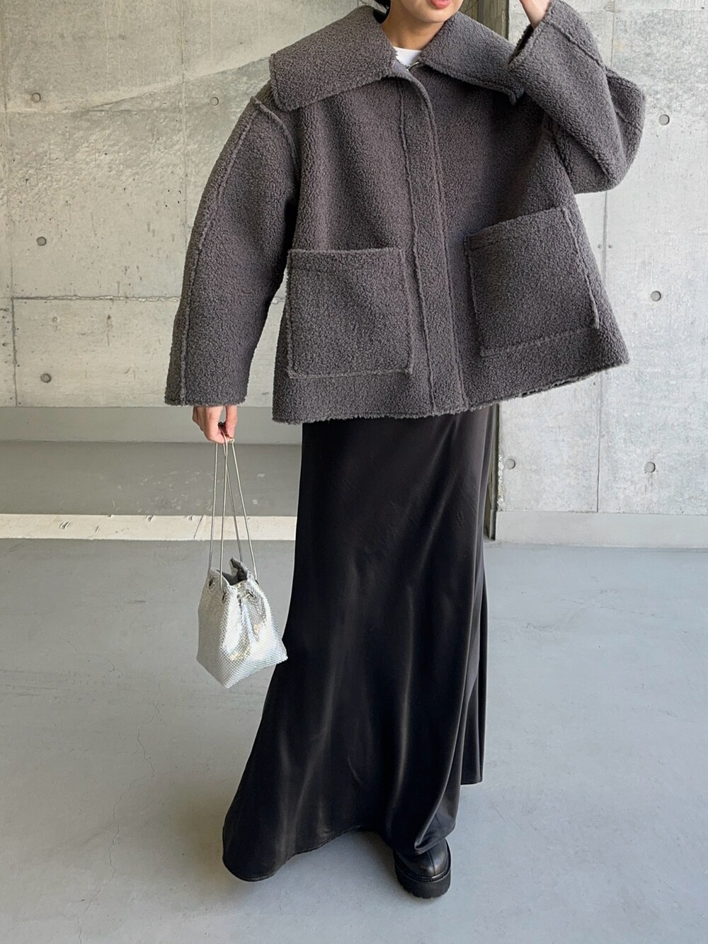 グレー系のその他アウター、シルバー系のショルダーバッグ、ブラック系のスカートを着用したレディースの冬コーディネートの4枚目の写真