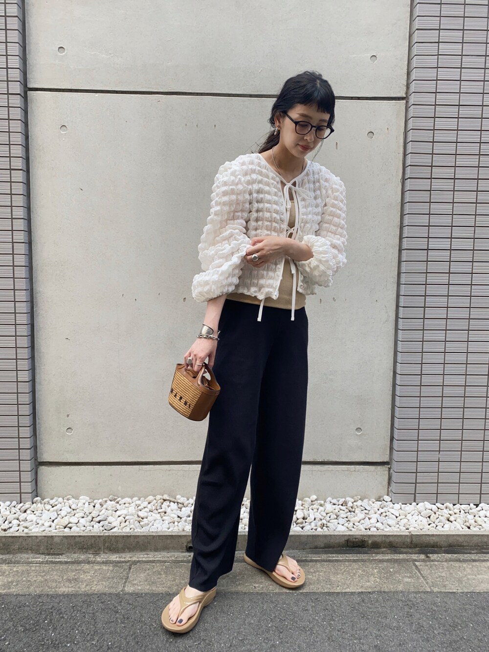 ホワイト系のトップス、ベージュ系のショルダーバッグ、ベージュ系のサンダルを着用したレディースの夏コーディネートの2枚目の写真