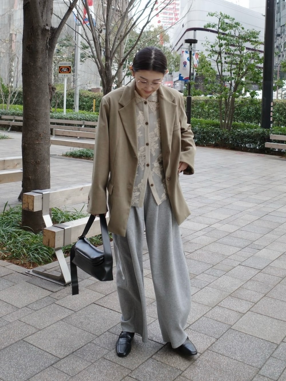 ベージュ系のテーラードジャケット、ブラック系のショルダーバッグ、グレー系のスウェットパンツを着用したレディースの春コーディネートの2枚目の写真