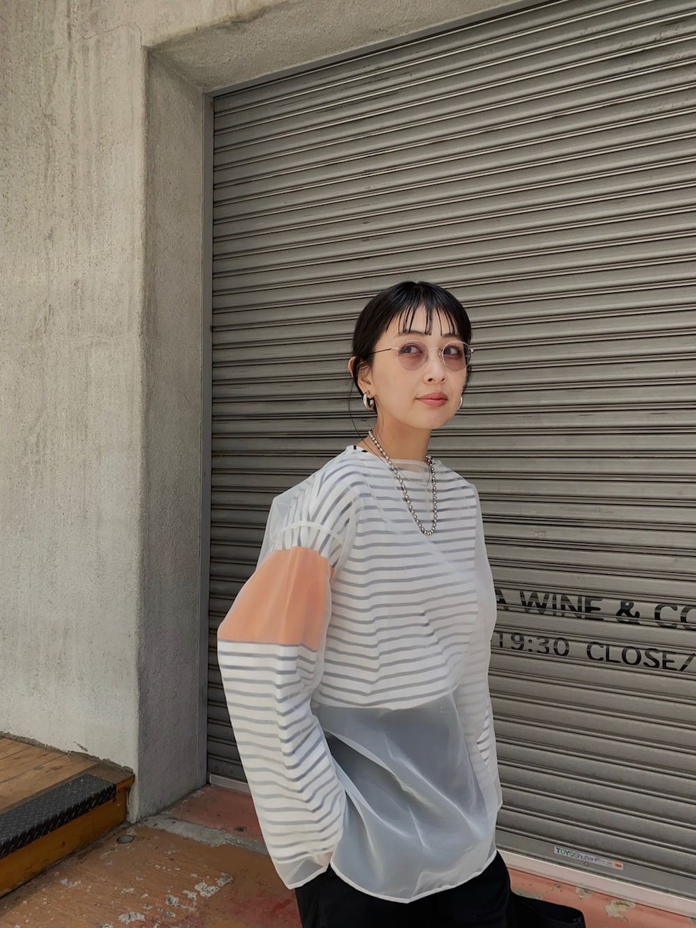 オレンジ系のTシャツ/カットソー、ブラック系のその他パンツ、ブラック系のバレエシューズを着用したレディースの春コーディネートの3枚目の写真