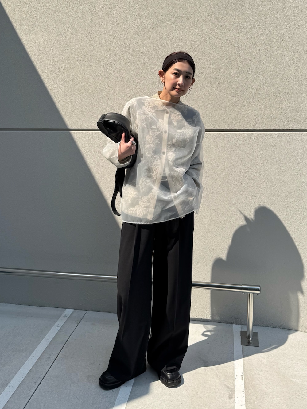 ホワイト系のシャツ/ブラウス、ブラック系のスラックス、ブラック系のローファーを着用したレディースの春コーディネートの2枚目の写真