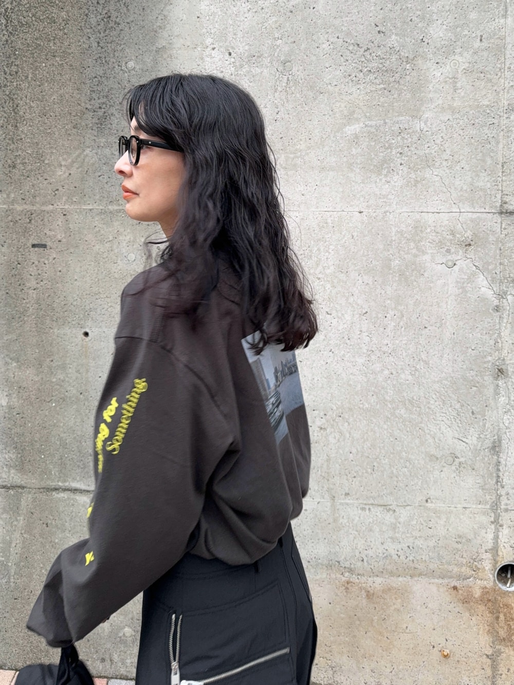 グリーン系のカーゴパンツ、グレー系のTシャツ/カットソー、ブラック系のバックパック/リュックを着用したレディースの秋コーディネートの4枚目の写真