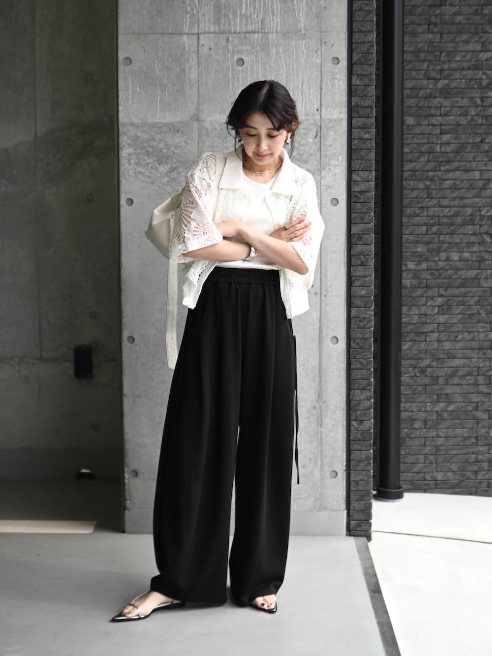 ホワイト系のシャツ/ブラウス、ブラック系のスウェットパンツ、シルバー系のサンダルを着用したレディースの夏コーディネートの4枚目の写真