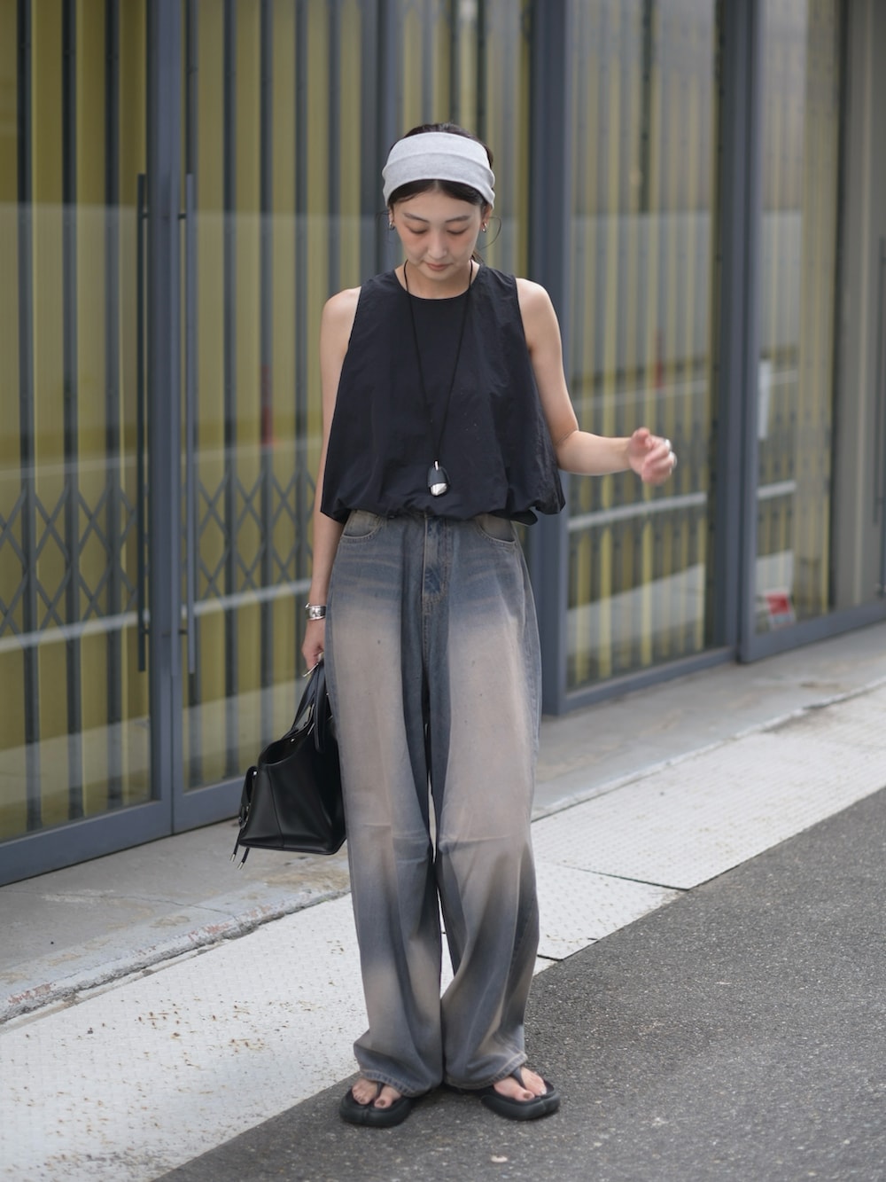 ブルー系のデニムパンツ、ブラック系のシャツ/ブラウス、ブラック系のトートバッグを着用したレディースの夏コーディネートの4枚目の写真