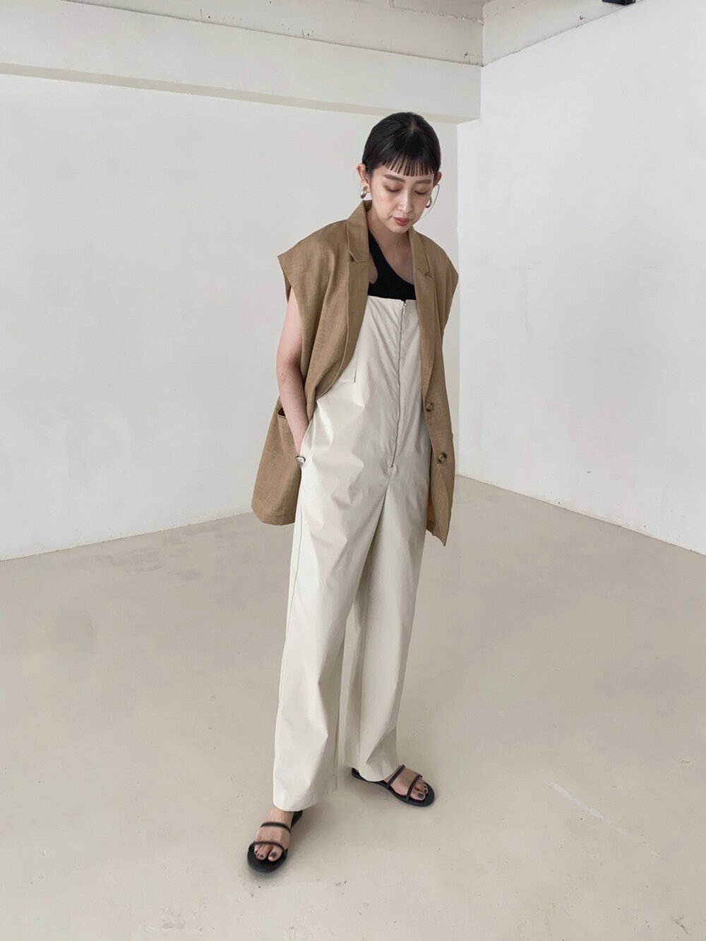 ホワイト系のサロペット/オーバーオール、ブラック系のサンダル、ブラック系のニット/セーターを着用したレディースの夏コーディネートの3枚目の写真