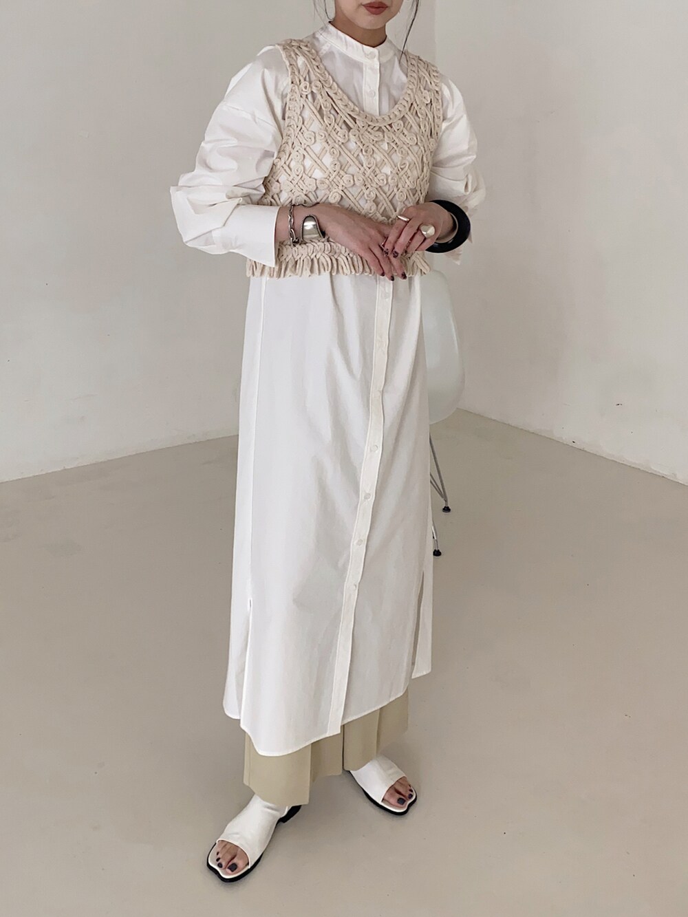 ホワイト系のベスト、ホワイト系のシャツワンピースを着用したレディースの春コーディネートの2枚目の写真