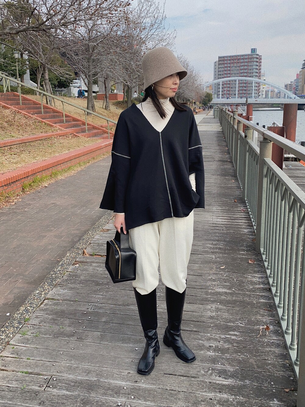 ブラック系のスウェット、ホワイト系のその他パンツ、ベージュ系の帽子を着用したレディースの冬コーディネートの4枚目の写真