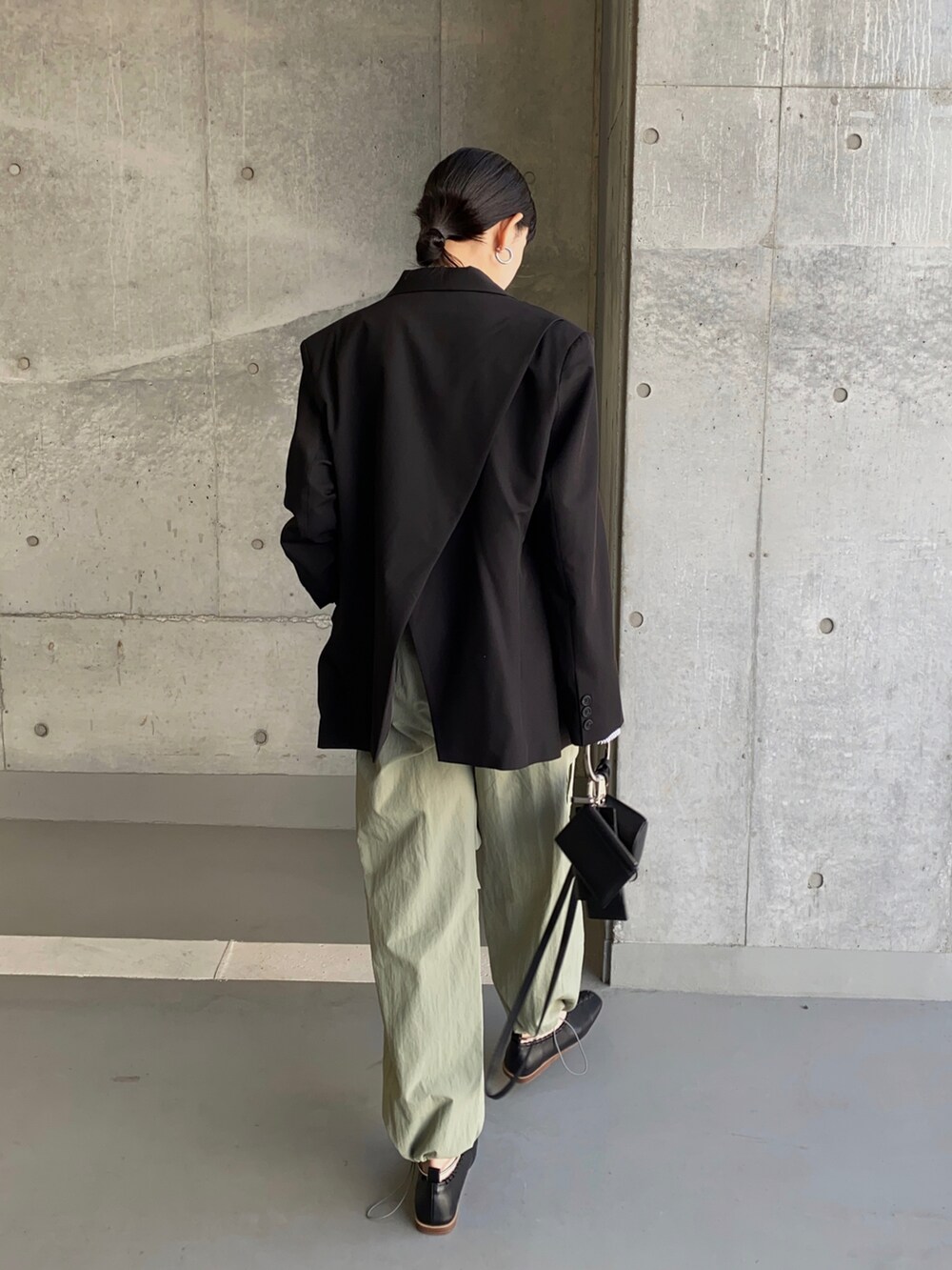 ブラック系のテーラードジャケット、ホワイト系のキャミソール、グリーン系のカーゴパンツを着用したレディースの春コーディネートの3枚目の写真