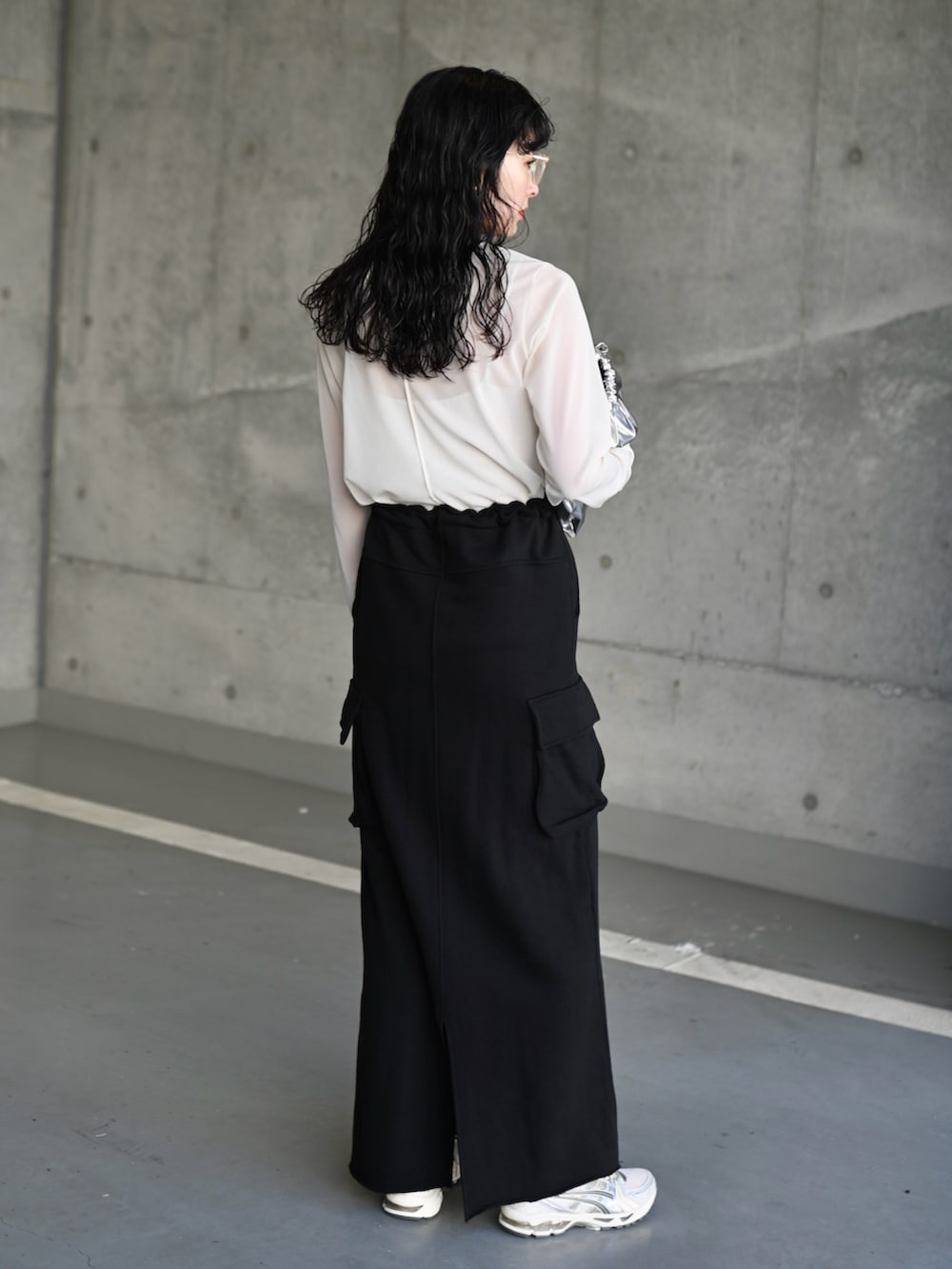 ホワイト系のTシャツ/カットソー、ブラック系のスカート、シルバー系のスニーカーを着用したレディースの夏コーディネートの4枚目の写真