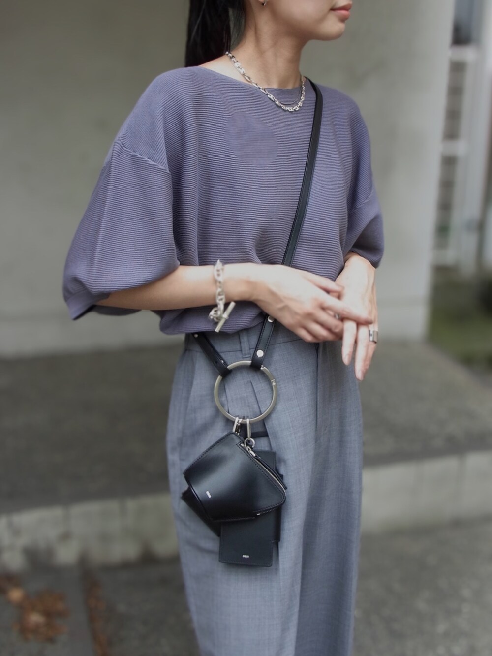 ブルー系のニット/セーター、グレー系のスラックス、ブラック系のショルダーバッグを着用したレディースの秋コーディネートの4枚目の写真