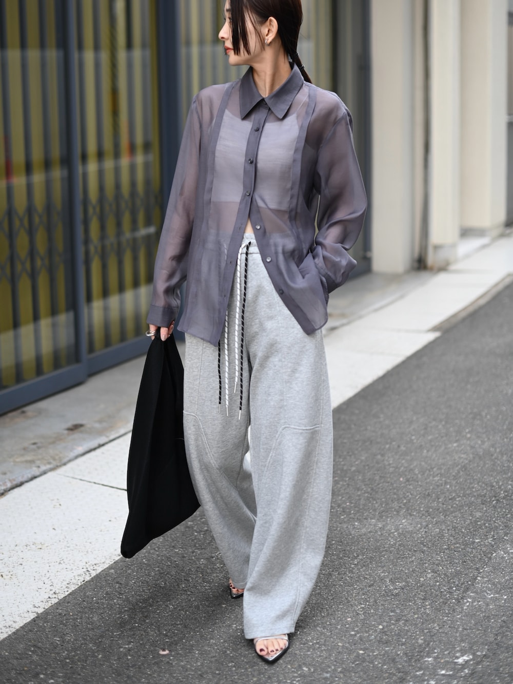 グレー系のシャツ/ブラウス、グレー系のスウェットパンツ、ブラック系のハンドバッグを着用したレディースの夏コーディネートの2枚目の写真