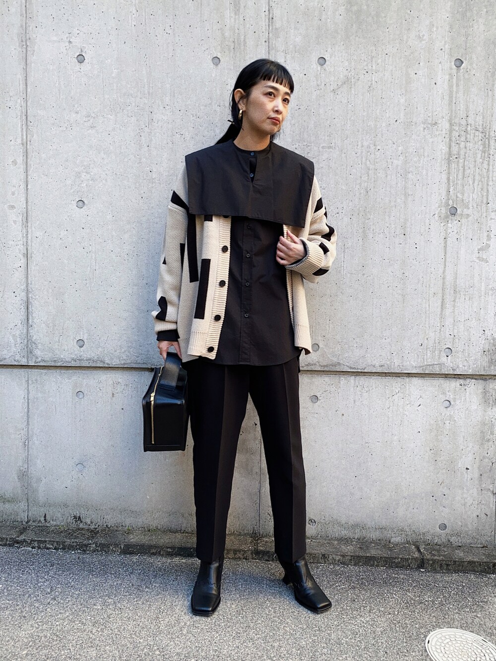 ベージュ系のカーディガン/ボレロ、ブラック系のシャツ/ブラウス、ブラック系のブーツを着用したレディースの冬コーディネートの4枚目の写真