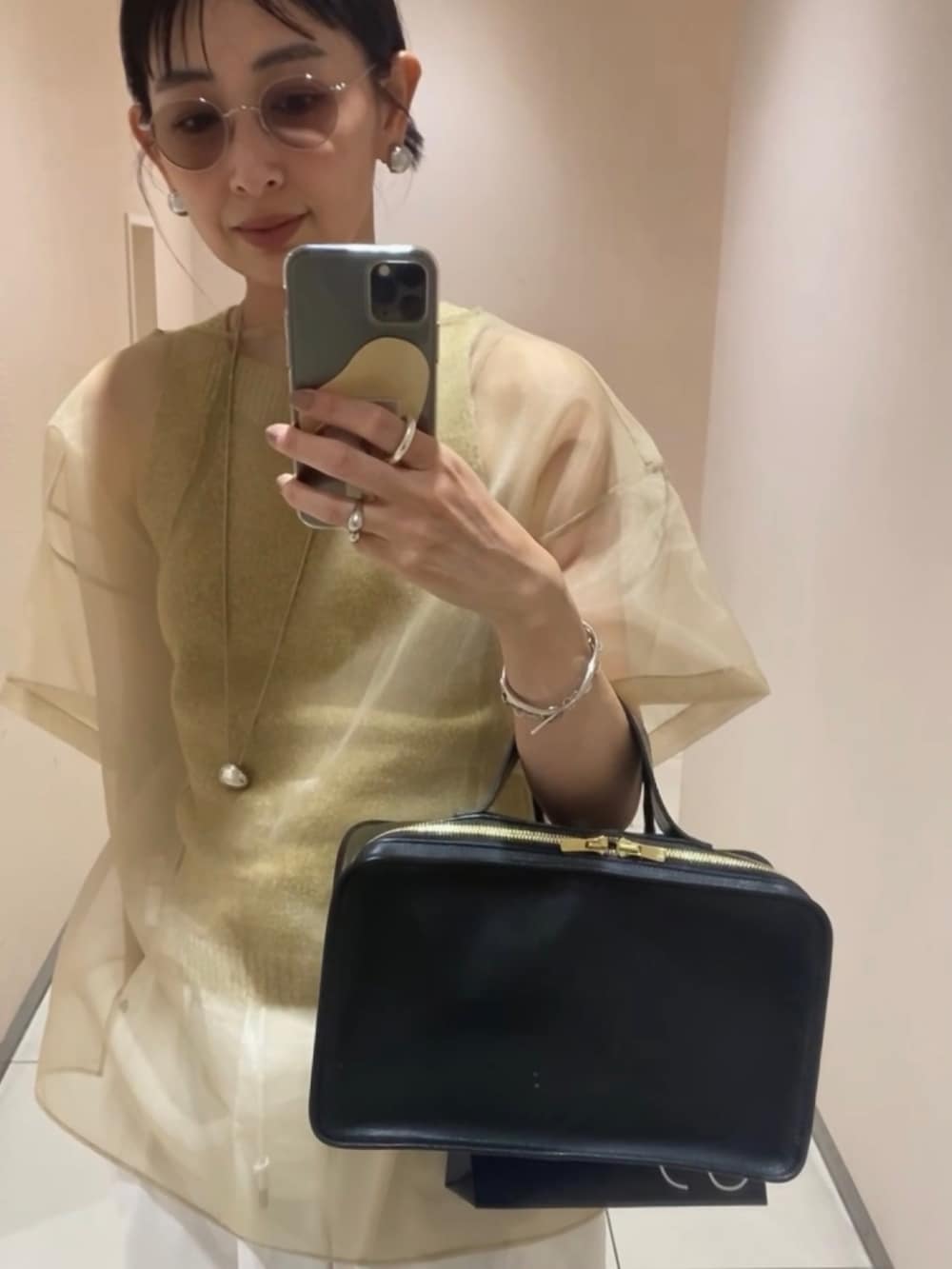 グリーン系のタンクトップ、ベージュ系のシャツ/ブラウス、ブラウン系のサンダルを着用したレディースの夏コーディネートの3枚目の写真