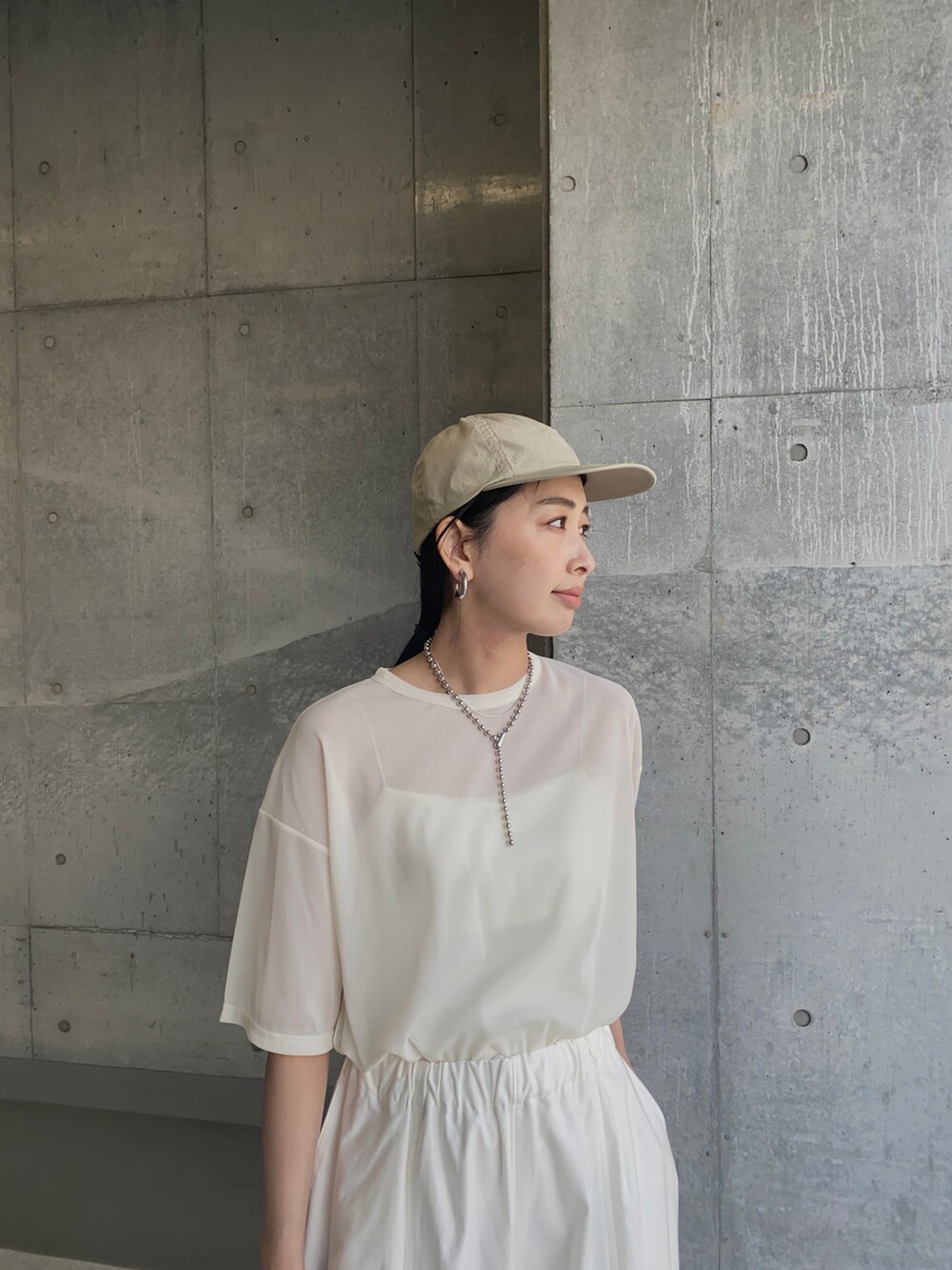 ホワイト系のTシャツ/カットソー、ホワイト系のチノパンツ、ホワイト系のサンダルを着用したレディースの夏コーディネートの2枚目の写真