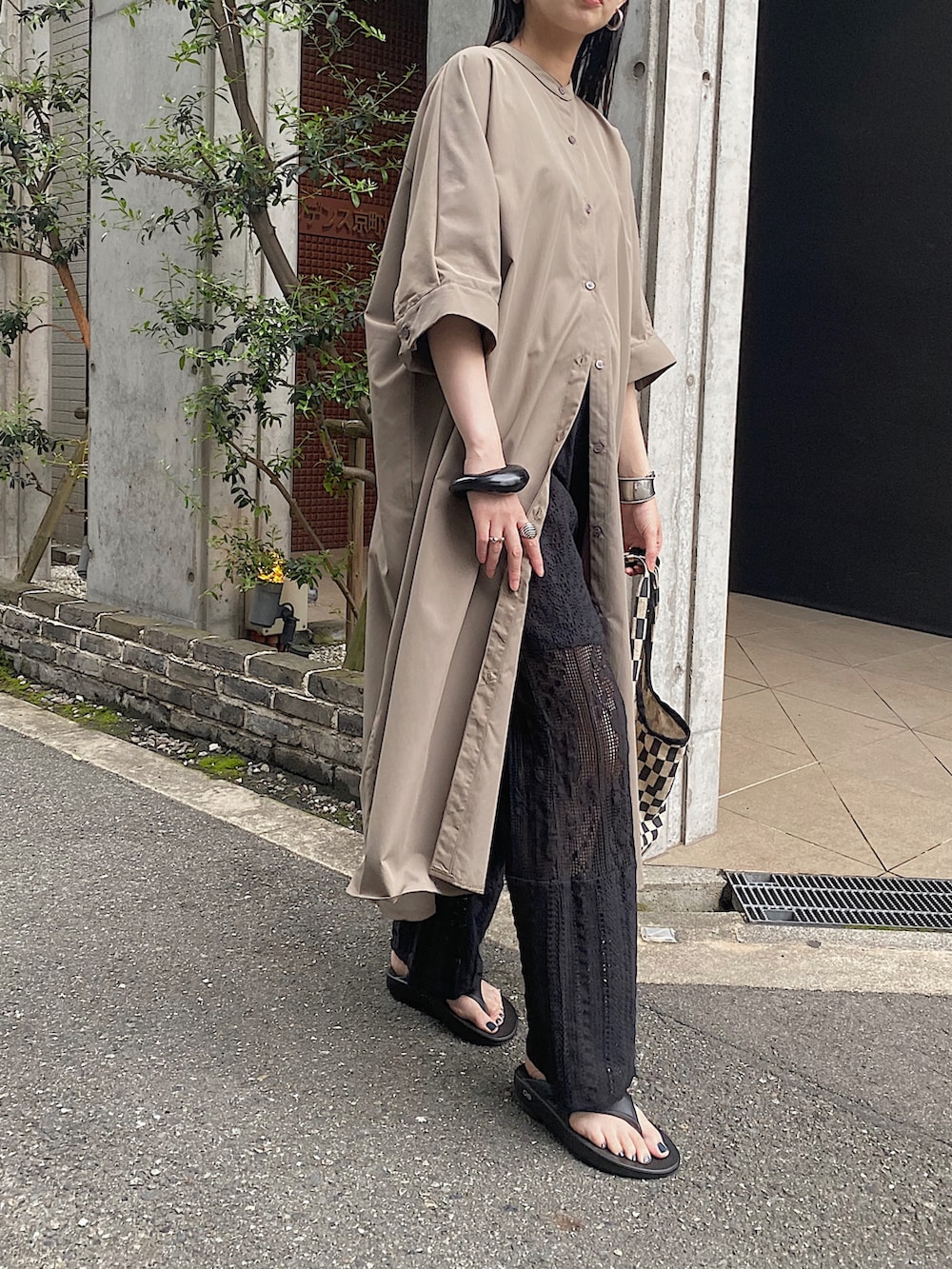 グリーン系のシャツワンピース、ブラック系のその他パンツ、ブラック系のトートバッグを着用したレディースの春コーディネートの2枚目の写真