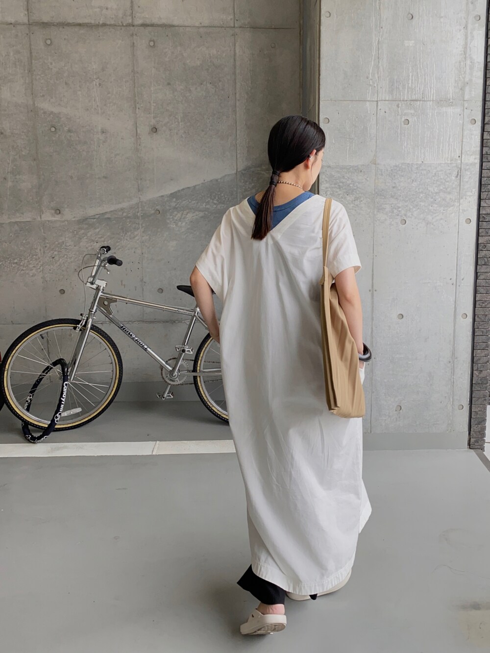 ホワイト系のワンピース、ブルー系のタンクトップ、ホワイト系のサンダルを着用したレディースの夏コーディネートの2枚目の写真