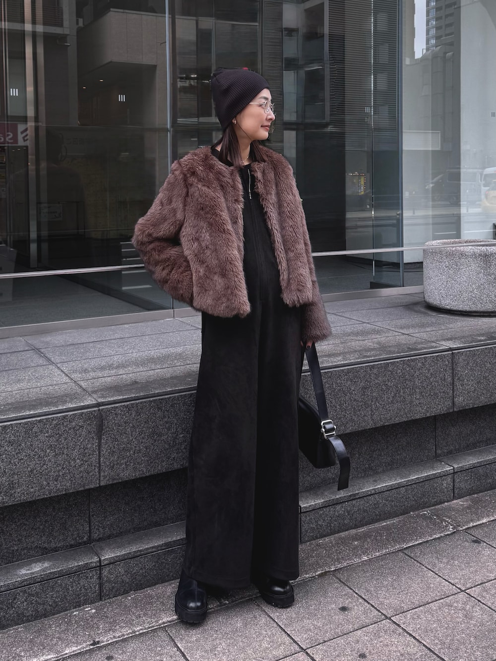 ブラウン系のその他アウター、ブラック系のショルダーバッグ、ブラウン系のつなぎ/オールインワンを着用したレディースの冬コーディネートの2枚目の写真