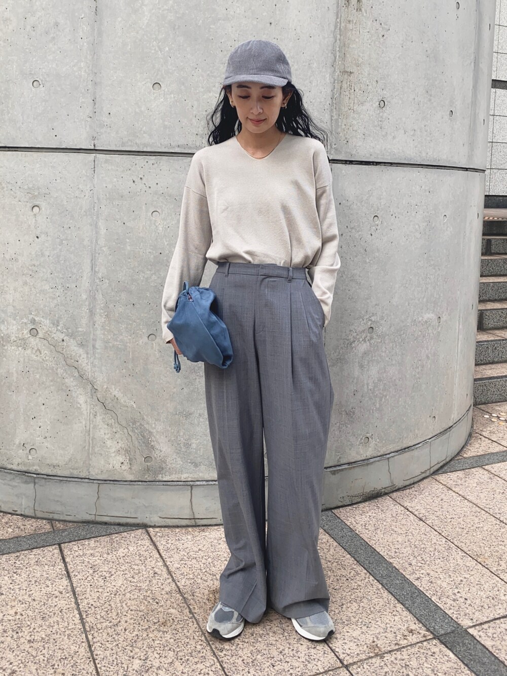 グレー系のニット/セーター、グレー系のスラックス、グレー系のスニーカーを着用したレディースの秋コーディネートの4枚目の写真