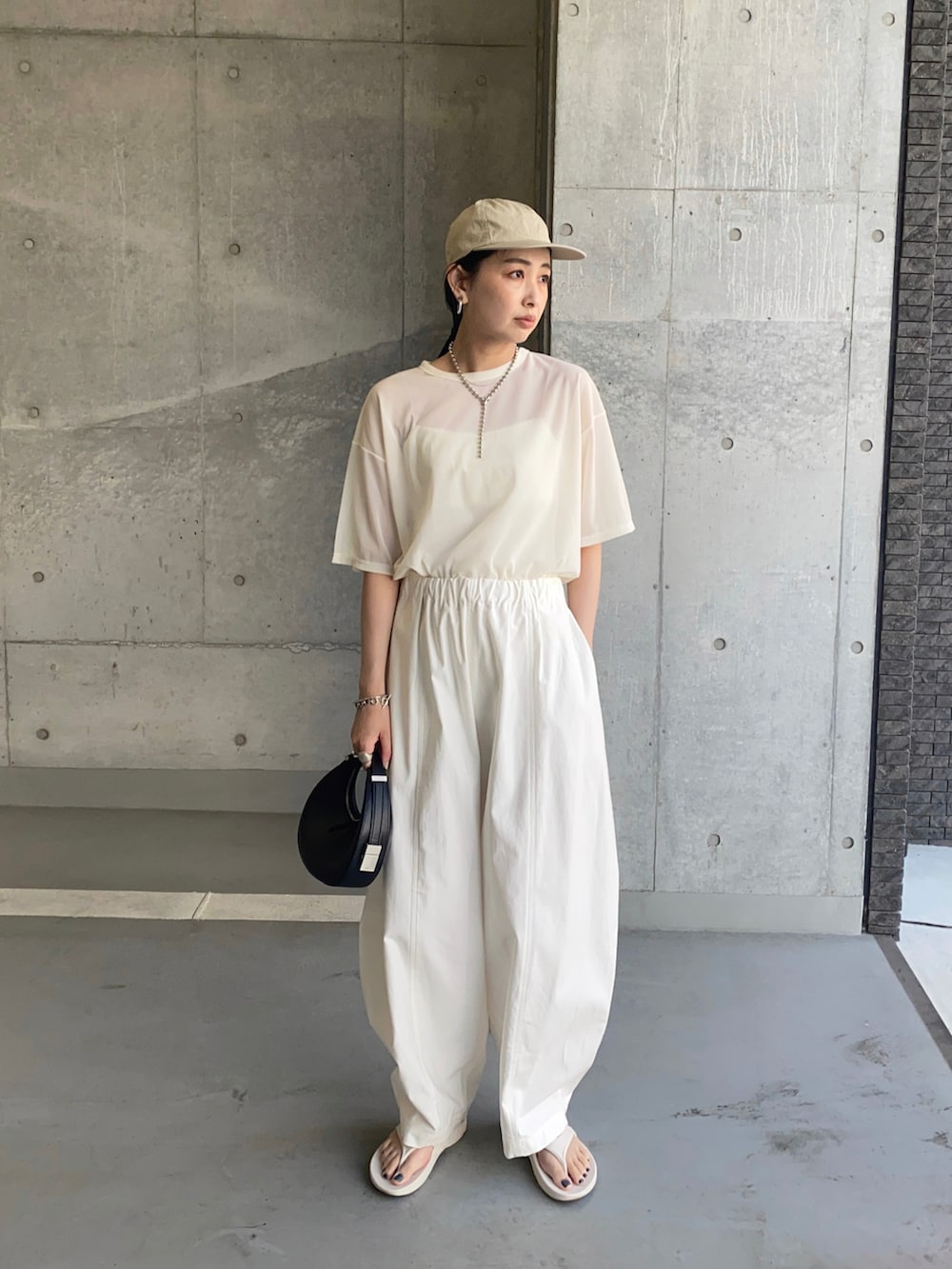 ホワイト系のTシャツ/カットソー、ホワイト系のチノパンツ、ホワイト系のサンダルを着用したレディースの夏コーディネートの4枚目の写真