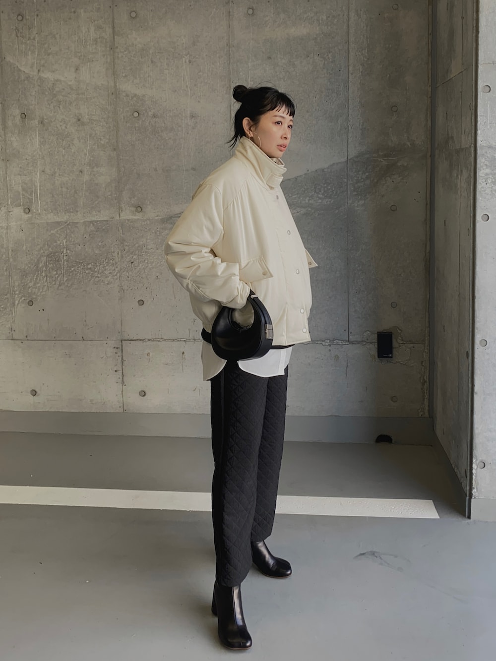 ホワイト系のブルゾン、ブラック系のその他パンツ、ブラック系のハンドバッグを着用したレディースの冬コーディネートの2枚目の写真