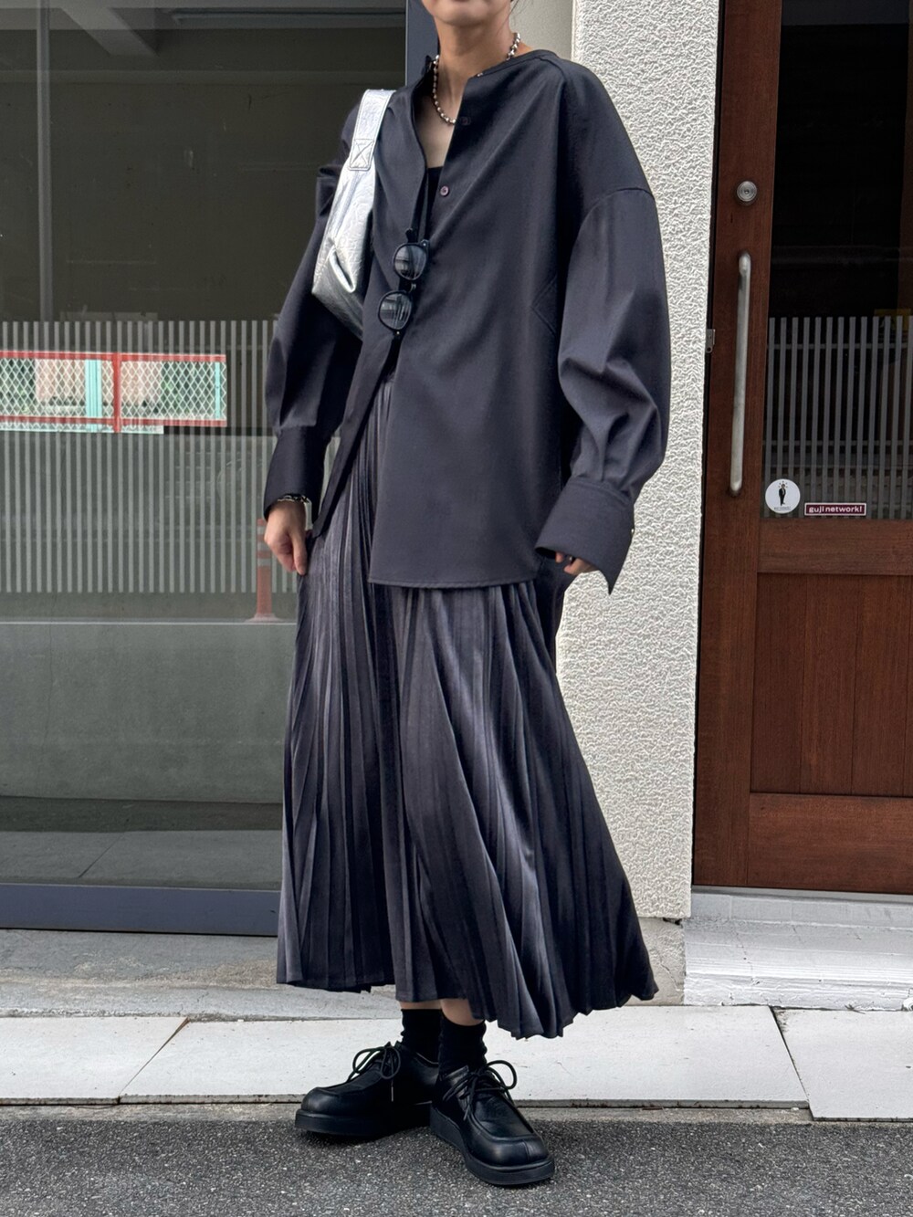 グレー系のスカート、グレー系のシャツ/ブラウス、シルバー系のショルダーバッグを着用したレディースの秋コーディネートの4枚目の写真