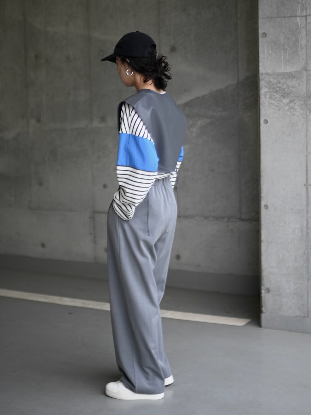 ブルー系のTシャツ/カットソー、グレー系のベスト、グレー系のスラックスを着用したレディースの春コーディネートの2枚目の写真